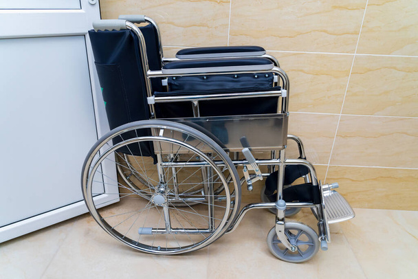 Folding wheelchair for people with special needs or disabilities with selective focus and blurry background, toned. Health and medicine. - Foto, immagini
