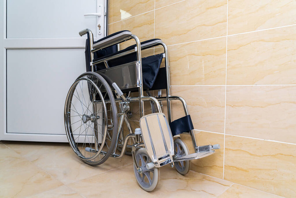 Folding wheelchair for people with special needs or disabilities with selective focus and blurry background, toned. Health and medicine. - Photo, Image