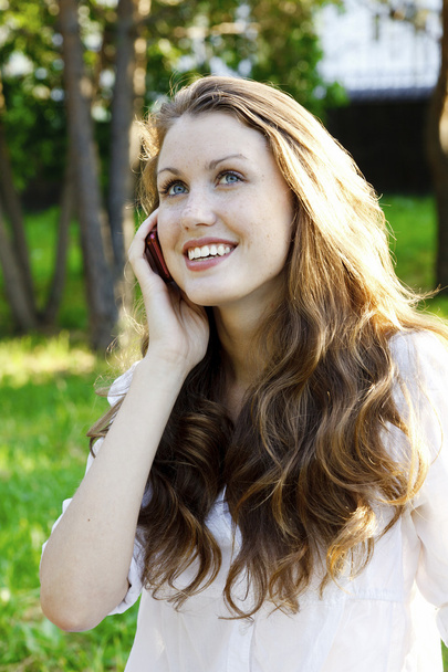 jonge lachende vrouw spreekt door mobiele telefoon - Foto, afbeelding
