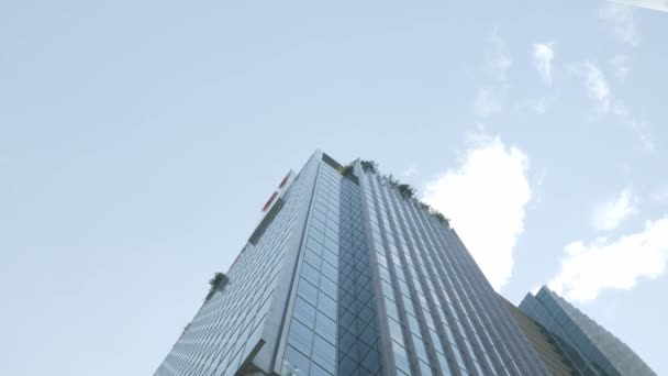 Primer plano steadicam plano de fachada de vidrio moderno edificio de oficinas en el distrito de negocios con gafas espejo de pared con cielo azul en el área del distrito financiero - Metraje, vídeo