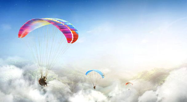 Paragliding multicolor. Paraglider flying over Landscape from the background Beauty nature mountain landscape of the sky. Paragliding Sports. Concept of extreme sport, taking adventure challenge. - Foto, imagen