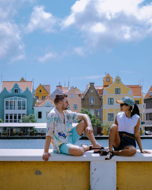 Curazao, Antillas Holandesas feliz pareja de mujeres asiáticas y hombres caucásicos visitan Curazao, Vista de coloridos edificios del centro de Willemstad Curazao Caribbean Island - Foto, Imagen