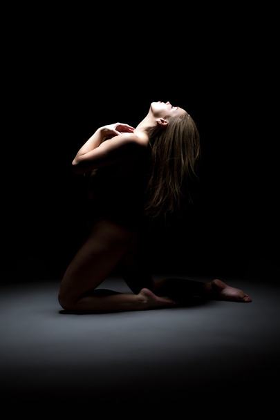 Studio shot of sensual naked girl kneeling - Fotó, kép