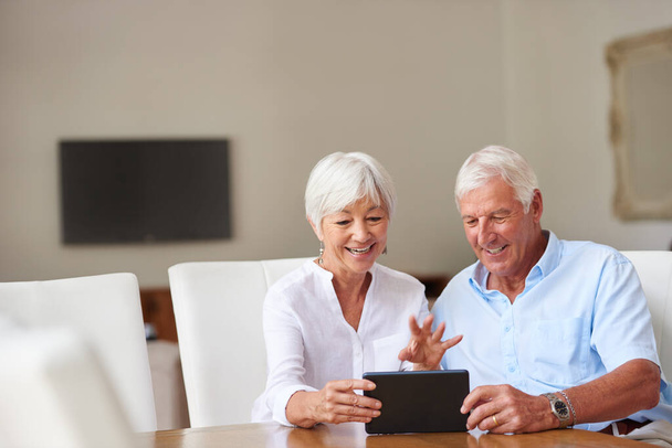 Warte, also ist eine Tablette kein Medikament. ein älteres Ehepaar mit einem digitalen Tablet zu Hause - Foto, Bild