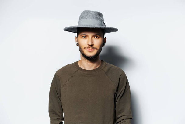 Studio portrait of young attractive man, wearing grey hat. - Photo, Image