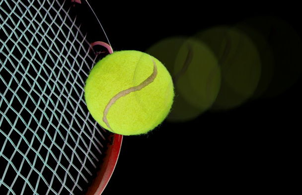 Tennis ball and racquet over black - Foto, immagini