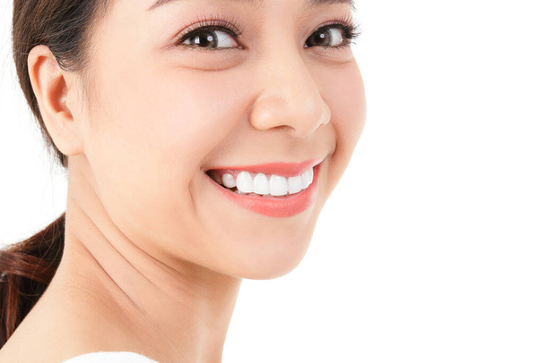 Концепция красоты. красивая азиатская женщина имеет красивые, чистые зубы Яркая, здоровая кожа. белый фон. - Фото, изображение