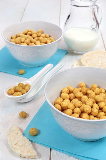 Copos de maíz en tazón y leche sobre fondo blanco
 - Foto, imagen