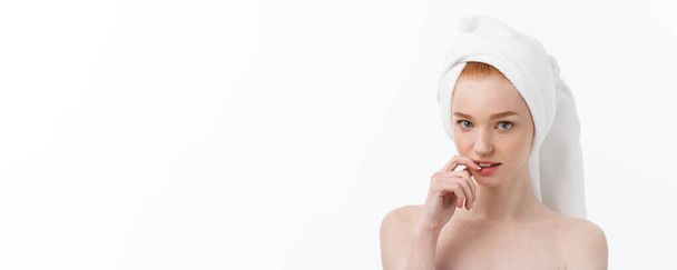 Zaskoczona piękna młoda kobieta po kąpieli z ręcznikiem na głowie odizolowana na białym tle. Pielęgnacja skóry i Spa Theme - Zdjęcie, obraz