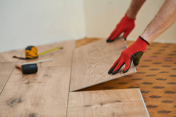 vinyl flooring. Worker installing planks with under laying at home flooring renovation. - Zdjęcie, obraz