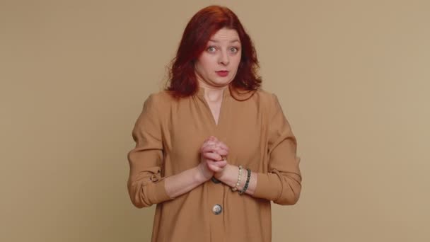 Dont want to look at ther, awful. Shocked millennial woman closing eyes with hand showing stop gesture, confused shy scared to watch. Young adult redhead girl isolated alone on beige studio background - Séquence, vidéo