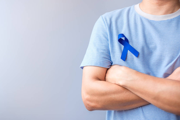 Março mês de conscientização do câncer colorretal, Mulher segurando fita azul escuro para apoiar as pessoas que vivem e doença. Saúde, esperança e conceito Dia Mundial do Câncer - Foto, Imagem