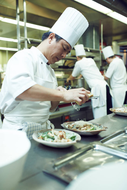 Preparándose para el servicio. chefs preparando un servicio de comidas en una cocina profesional - Foto, Imagen