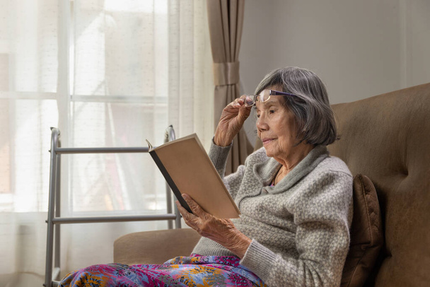 Asiatique femme âgée lit un livre pour se détendre à la maison de soins infirmiers. - Photo, image