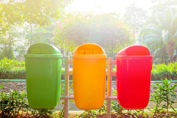 Bahçe bölgesinde yeşil, sarı ve kırmızı çöp bidonları - Fotoğraf, Görsel