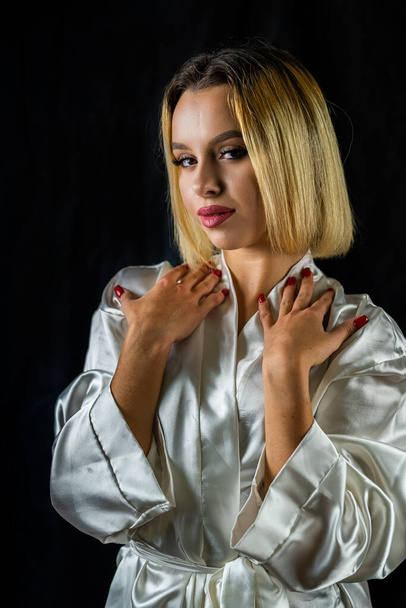 pretty young woman in a light silk robe showing comfort and joy. isolated on a plain background. concept of portrait photography. girl - Photo, Image