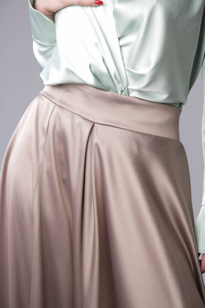 Студійний знімок моделі жіночої моди в спідниці бежевого максі кола, Спрощена та елегантна шовкова атласна спідниця повної довжини
 - Фото, зображення