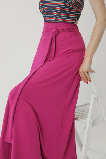 Serie of studio photos of young female model in comfortable cotton pink maxi skirt. - Photo, Image