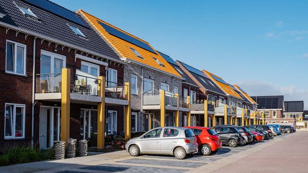 Nowe domy z panelami słonecznymi przymocowane na dachu pod słonecznym niebem, nowe budynki z czarnymi panelami słonecznymi. Zonnepanelen, Zonne energie, Tłumaczenie: Panel słoneczny Energia słoneczna. Niderlandy - Zdjęcie, obraz