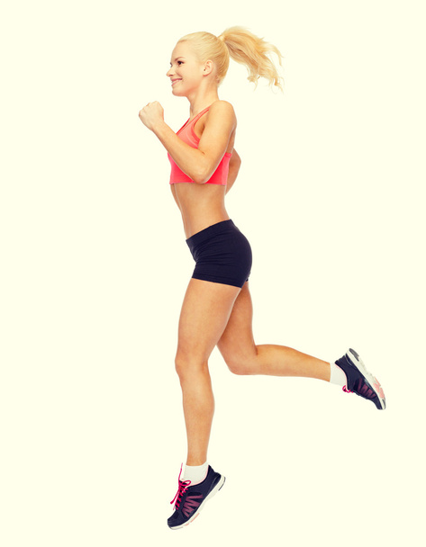 sporty woman running or jumping - Fotó, kép