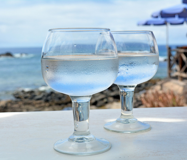 Празднование с двумя бокалами на фоне моря
 - Фото, изображение
