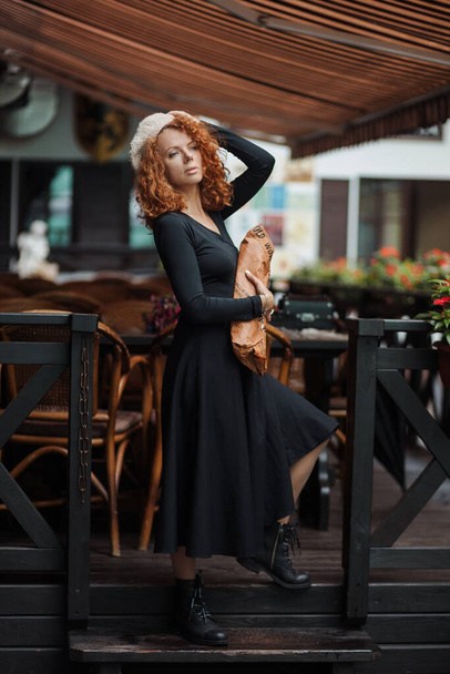 Жінка в береті і чорна сукня тримає багет в руках тла
  - Фото, зображення