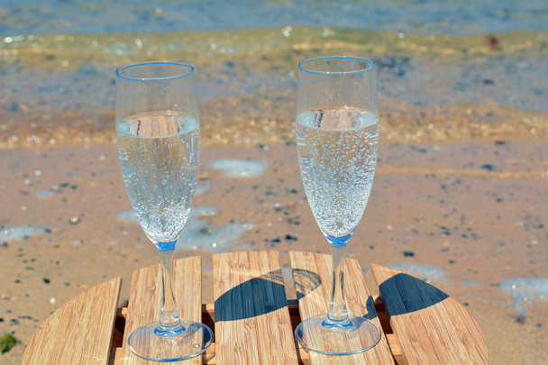 Празднование с двумя бокалами шампанского на райском пляже
 - Фото, изображение