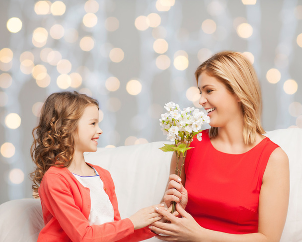 happy little daughter giving flowers to her mother - Zdjęcie, obraz