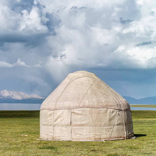 Traditional Yurt tent at the Song Kul lake plateau in Kyrgyzstan. Yurt tents are traditional, portable tents made of felt that are used as a form of accommodation in the country. - Foto, Bild