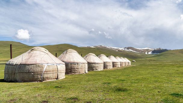 Traditional Yurt tent camp at the Song Kul lake plateau in Kyrgyzstan. Yurt tents are traditional, portable tents made of felt that are used as a form of accommodation in the country. - Photo, image