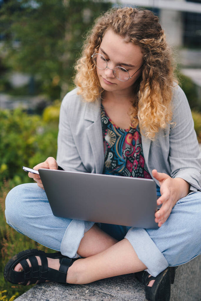 Portret wesołej kobiety z nowoczesną technologią telefonów komórkowych i laptopów cieszącej się wolnym stylem życia na świeżym powietrzu. Nowoczesna komunikacja. Komunikacja internetowa - Zdjęcie, obraz