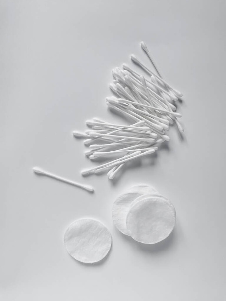 White cotton swabs and pads for daily feminine hygiene and care for the face and ears. Flat lay composition on the white background. - Foto, Imagen