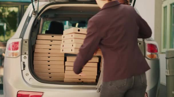 Employé de Pizzeria donnant des piles de boîtes de pizza à divers clients, prendre des paquets de repas hors du coffre du véhicule. Courrier de livraison de nourriture livrant des piles de fastfood aux clients qui attendent près de la porte d'entrée. - Séquence, vidéo