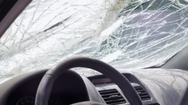 Cracked car windshield after an accident. Close-up of a wrecked vehicle after a collision with a pedestrian or car accident. Damaged vehicle. Road safety, car insurance. View from inside the cabin - Filmmaterial, Video