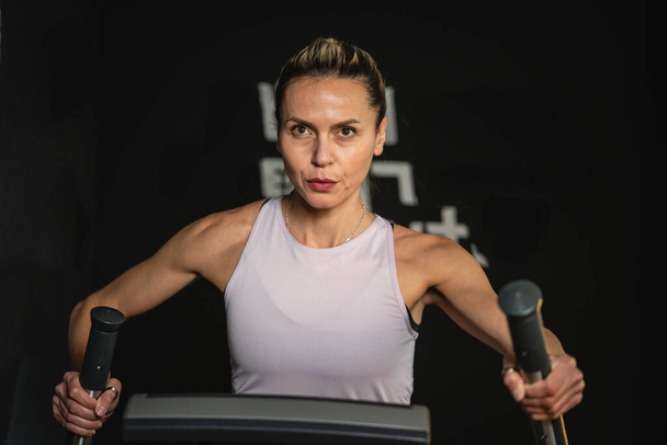 Egy kaukázusi érett nő gyakorlása Elliptical Cross Trainer képzés otthon vagy edzőteremben egészséges életmód egészség és fitness koncepció másolás tér - Fotó, kép