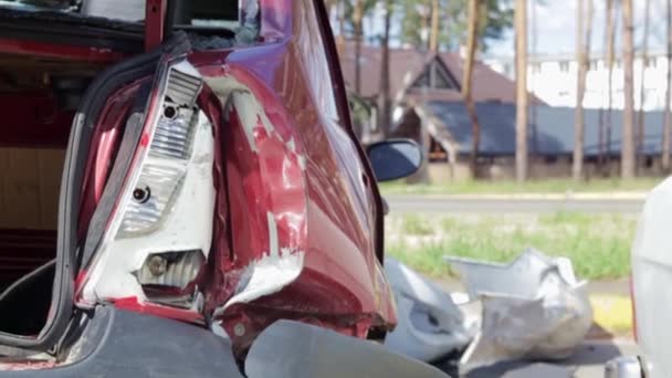 Red car after a terrible accident on the side of the road. Frontal and side impact. Life insurance. An accident without the possibility of recovery. Back view. Damage after an accident - Materiał filmowy, wideo
