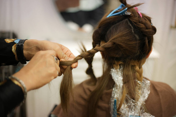 Male hairdresser tying woman's hair - Foto, imagen
