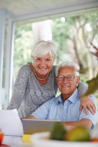 Ci occupiamo delle nostre finanze. una coppia anziana che usa un tablet digitale e tiene documenti - Foto, immagini