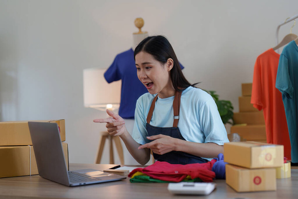 Asian Woman Modedesignerin Stoffschneiderin kreative Arbeit für neue Kollektion. Glücklicher Online-Ladenbesitzer bereitet Bestellung für den Versand vor. - Foto, Bild