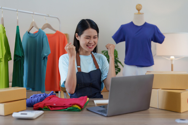 Asian Woman fashion designer cloth tailor creative working for new collection. Happy online store owner preparing an order for shipping. - Foto, imagen