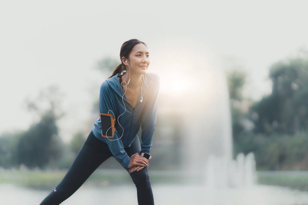 Gezonde Aziatische vrouw is buiten aan het joggen. Fitness meisje op de vlucht. Vrouwelijke lichaamsbeweging in het buitenpark. - Foto, afbeelding