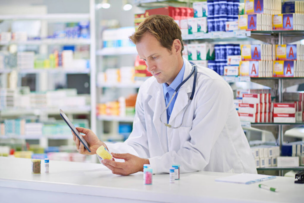 What else can this pill be used for. A pharmacist working on a digital tablet - Photo, image