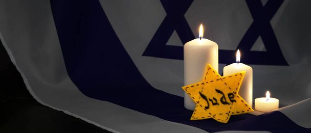 Ντέιβιντ Σταρ και αναμμένα κεριά στη σημαία του Ισραήλ. Διεθνής Ημέρα Μνήμης του Ολοκαυτώματος - Φωτογραφία, εικόνα