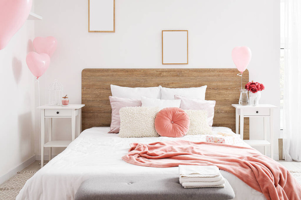 Interno della stanza luminosa con letto e palloncini rosa per San Valentino - Foto, immagini