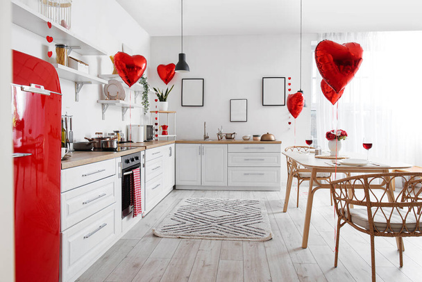 Εσωτερικό της κουζίνας με μετρητές, τραπεζαρία και μπαλόνια για την Ημέρα του Αγίου Βαλεντίνου - Φωτογραφία, εικόνα