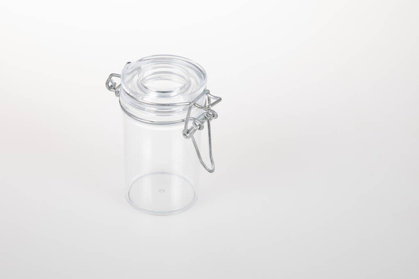 Κενό γυάλινο βάζο δοχείο με μεταλλικό σφιγκτήρα σε λευκό φόντο - Φωτογραφία, εικόνα