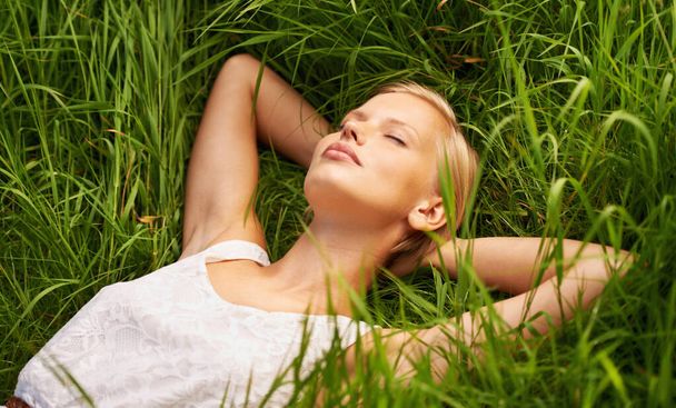 Κοιμόταν σε ανοιχτό χωράφι. Μια ελκυστική νεαρή γυναίκα κοιμάται σε ένα ανοιχτό πράσινο πεδίο - Φωτογραφία, εικόνα