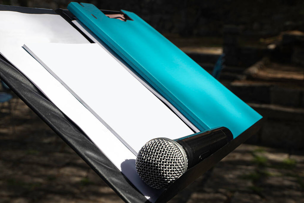 microphone on a podium lectern with blank papers. Conference concept. Selective focus. Mockup. - Photo, Image