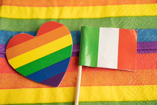 虹の背景にイタリアの国旗LGBTゲイプライド月間のシンボル社会運動虹の旗は、レズビアン、ゲイ、バイセクシャル、トランスジェンダー、人権、寛容と平和の象徴です。. - 写真・画像