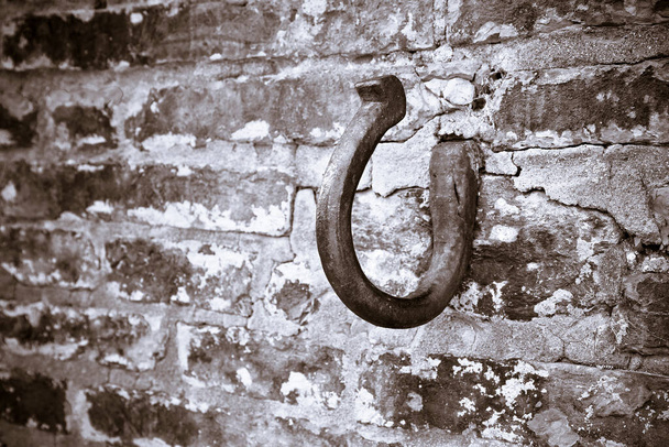 Σκουριασμένα γάντζο σε ένα πέτρινο τοίχο τούβλου - τονισμένο εικόνας - Φωτογραφία, εικόνα